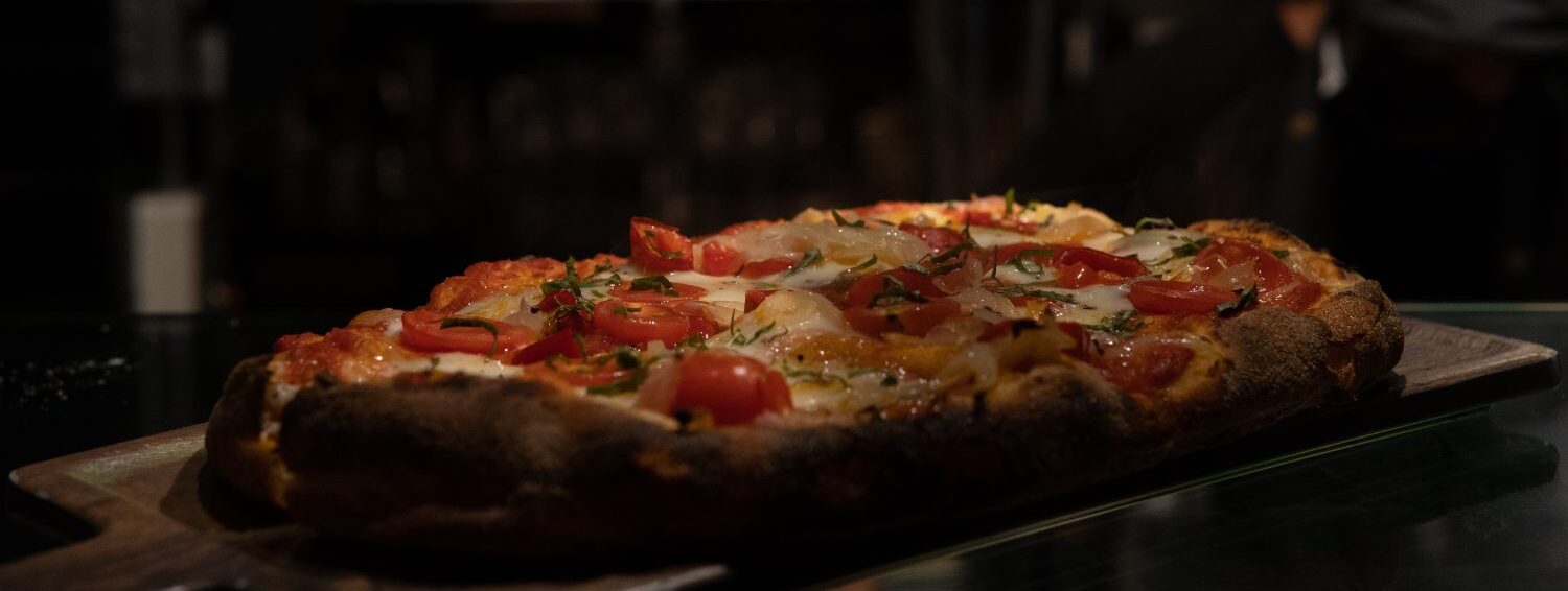 A Joe's pinsa with tomatoes and basil.